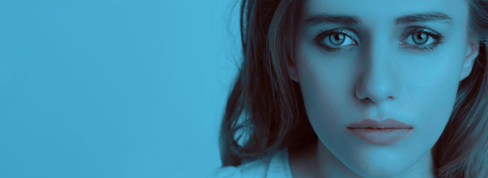 serious woman in blue field